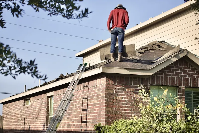 Professional roofer working on a residential roof in Elkins